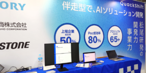 展示会場における株式会社QuackShiftのブース。松尾研究所発の伴走型AIソリューション開発や、上場企業取引率50%、PoC成功率80%などの実績を示すパネル展示の様子