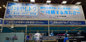 猛暑対策展で展示された「冷やしトク」のブース大型看板。「接触冷感でも、気化熱冷却でもない〜持続する冷たさ〜」「冷たさが持続する新素材 Téxion」「表面温度が最大-4℃」といったキャッチコピーやロゴが大きく掲げられている。