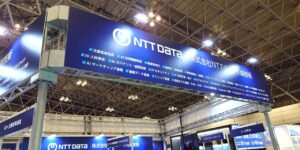 展示会場における株式会社NTTデータ先端技術のブース看板。AI人材育成やAIガバナンス、RAG精度改善、tsuzumi活用などAIソリューションの提供領域を一覧表示している様子